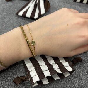 Henri Bendel Gold Cuff Bracelet with Green Charm